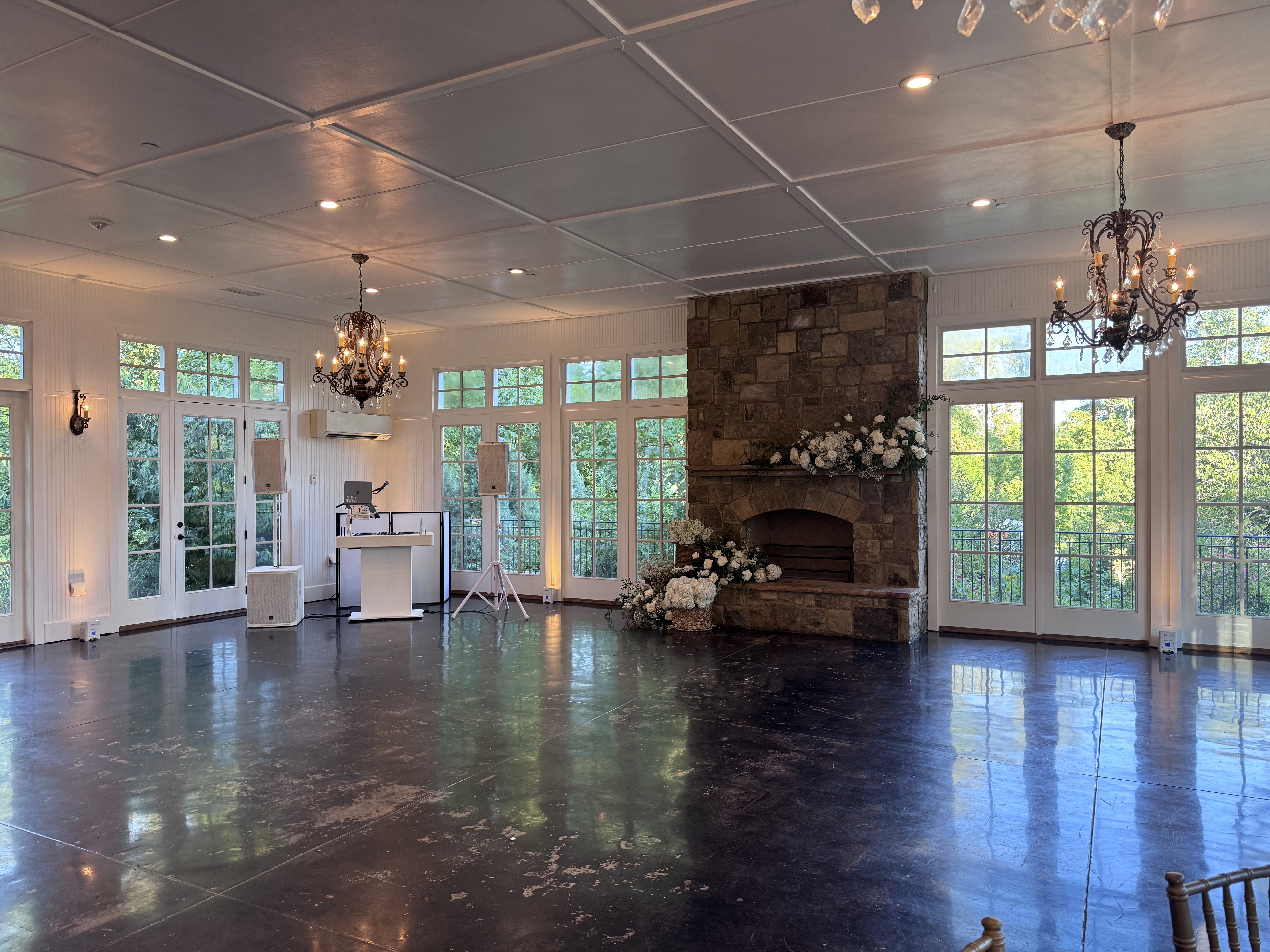 Warm white uplighting by the DJ booth and fireplace at Little River Farms